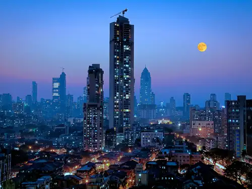 Indian property developer Rustomjee plans to build data centers in Mumbai, leveraging the AI boom while continuing to sell luxury homes. The data centers will be developed across 5 million square feet in Thane. Rustomjee aims to find a strategic or financial partner for the project, capitalizing on the growing demand for data center capacity.