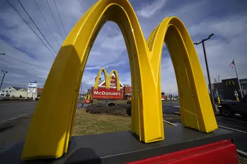 McDonald's is advancing towards a future with minimal human cashiers by introducing new digital ordering stations in the US. These stations, which can handle cash transactions and provide change, aim to reduce reliance on cashiers. Although human workers will remain in roles like food delivery and customer service, the new setup encourages customers to use kiosks or mobile apps, thus speeding up service and improving accuracy.